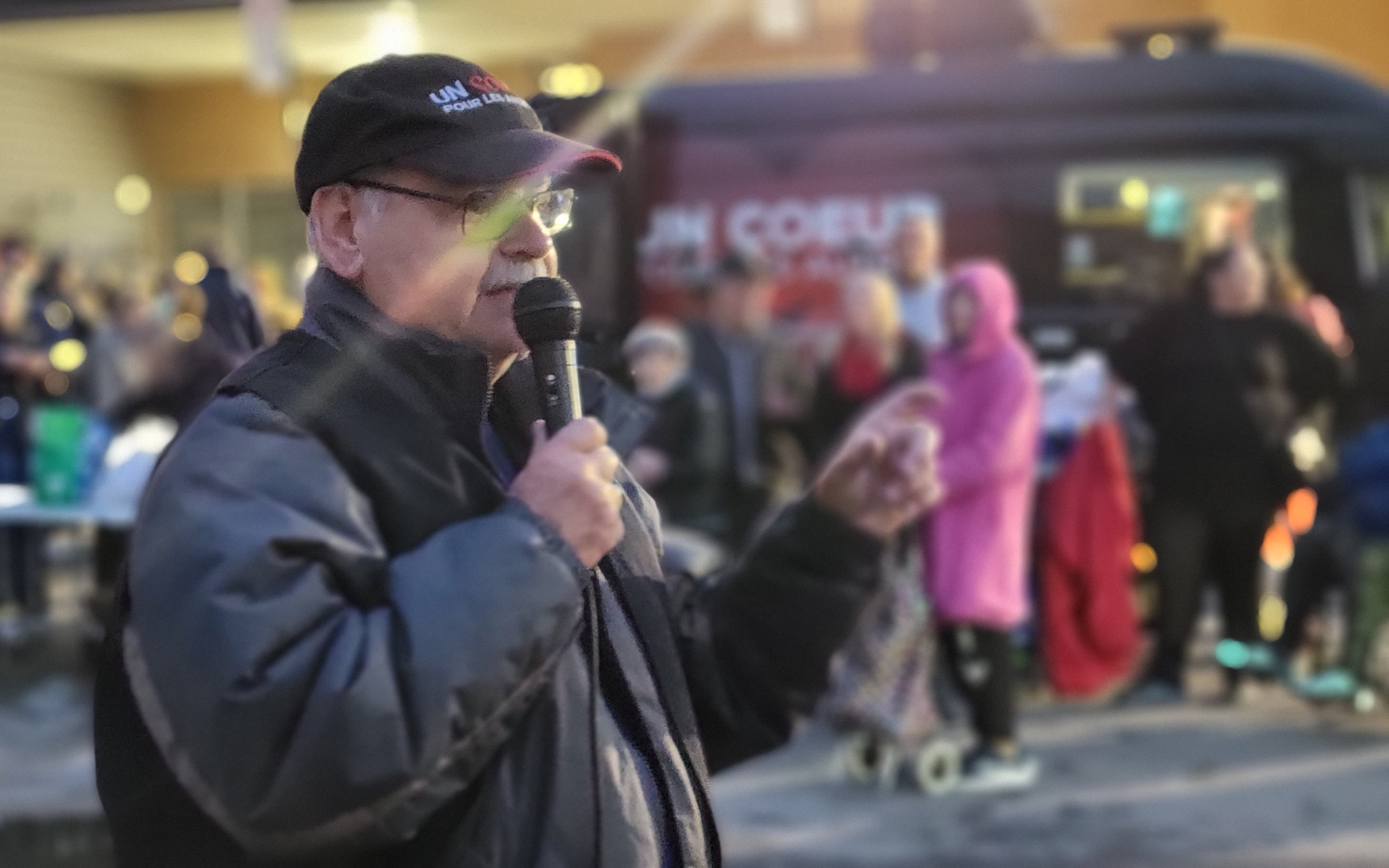 Homme âgé parlant dans un microphone lors d'un événement de l'organisme